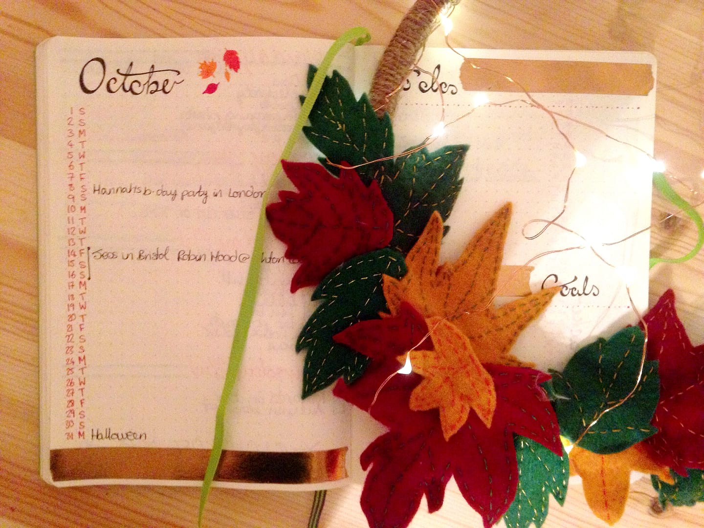 bullet journal autumn update. October's monthly calendar spread with autumnal leaf wreath and fairy lights