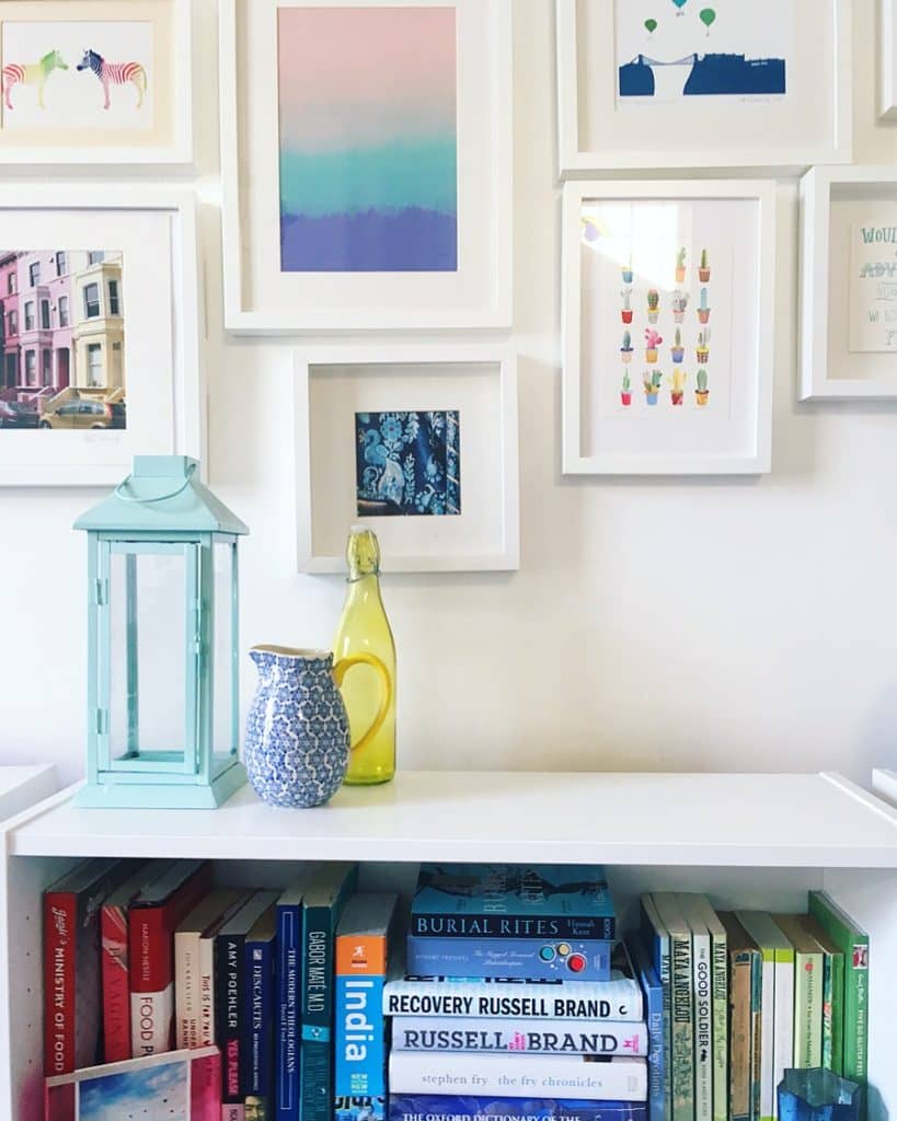 Colourful gallery wall and colour coordinated bookcase Living area tour yellow feather blog